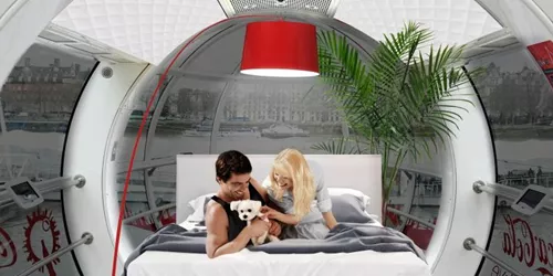 Apartment installed in London Eye with two people on bed
