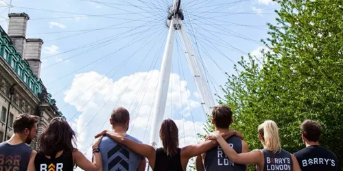 People standing in front of london eye in gym wear