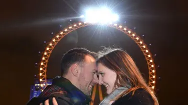 Happy couple engaged in front of London Eye