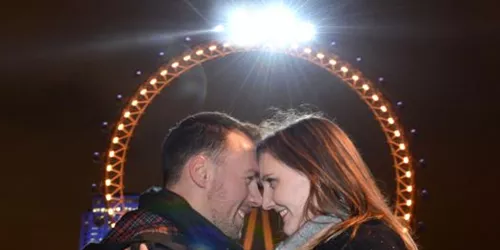 Happy couple engaged in front of London Eye